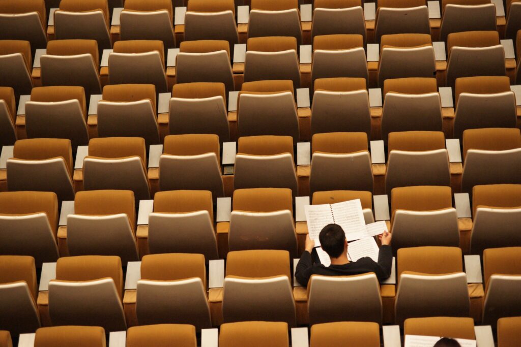 a man in an empty lecture hall, studying for an iq test, he is unsure how long it will take.